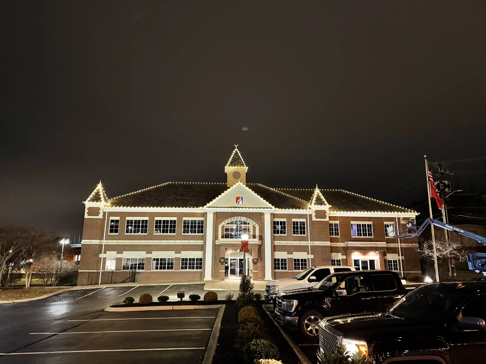 Commercial building with white holiday lighting along the roof and peaks