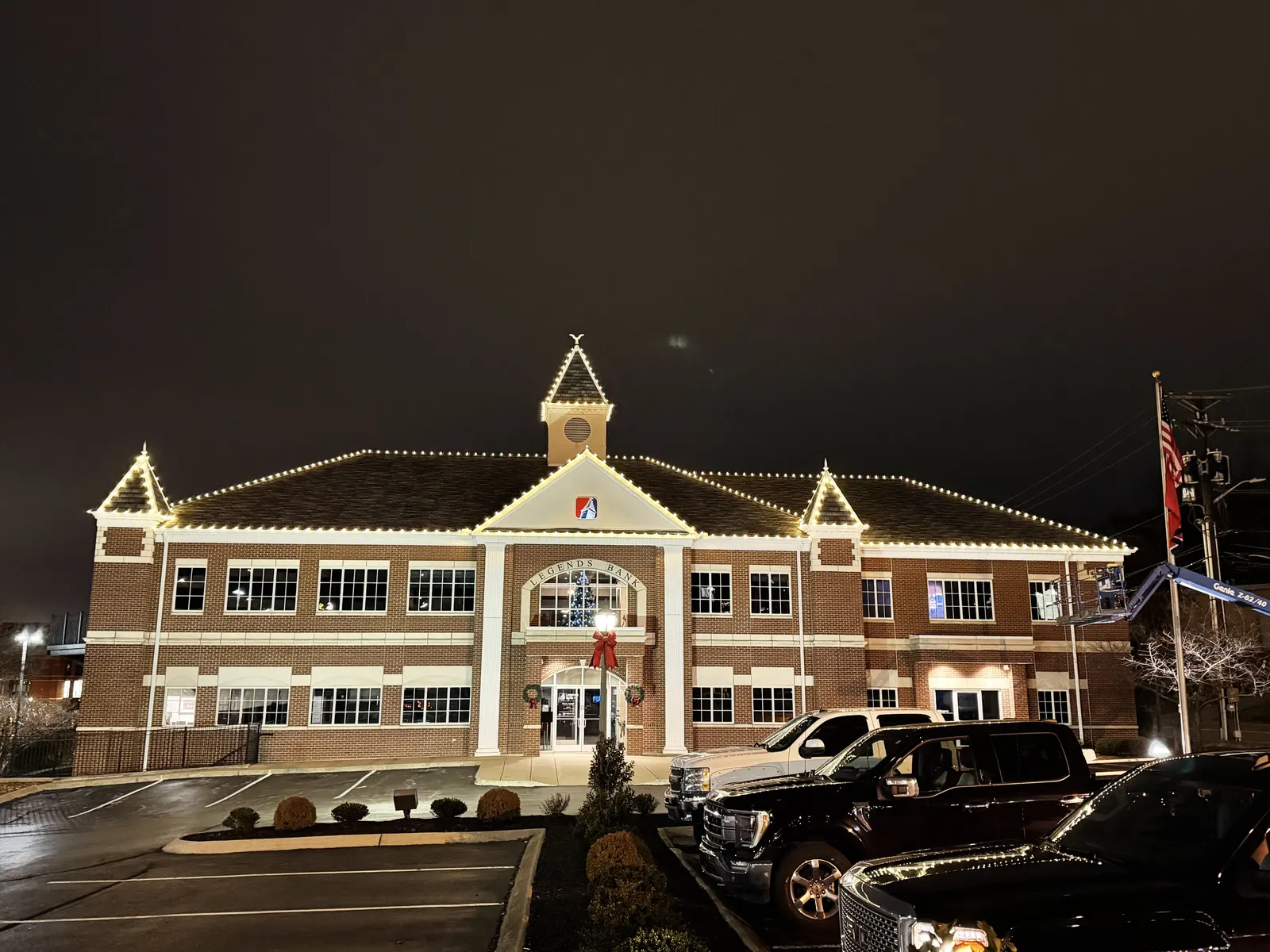 White roofline lights outlining a large commercial building at night