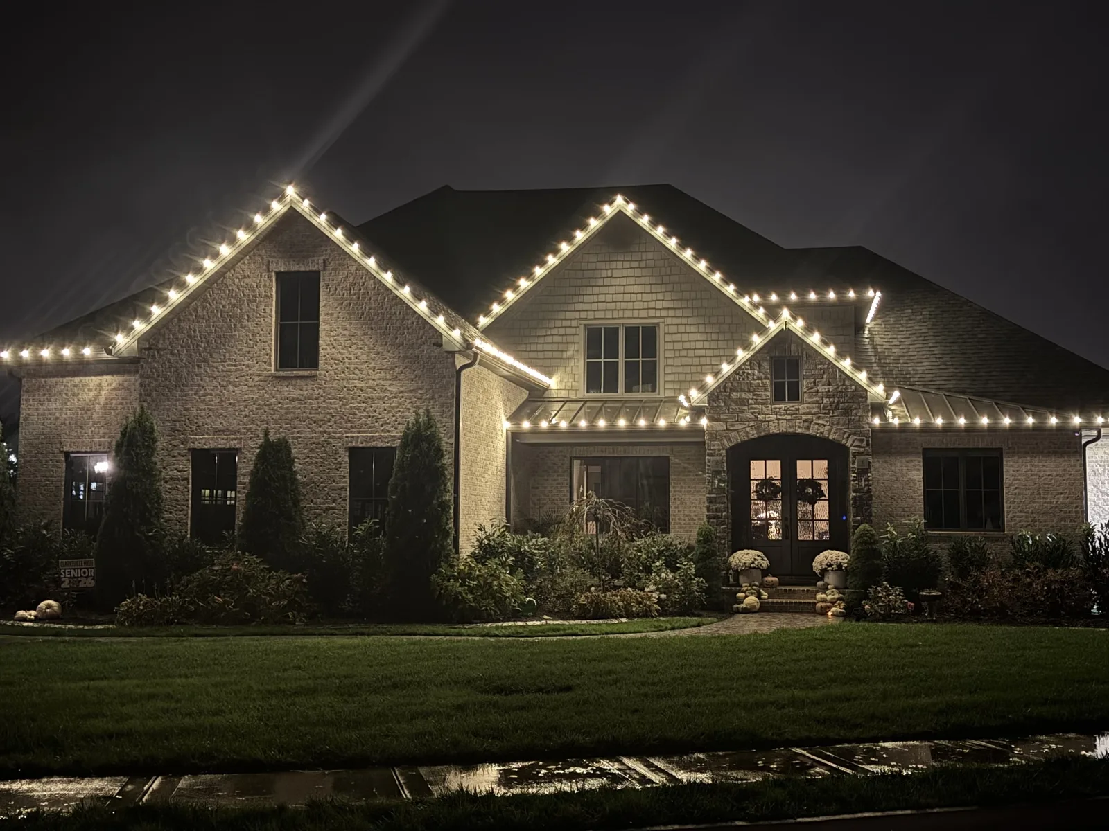Warm white Christmas lights outlining a two-story home